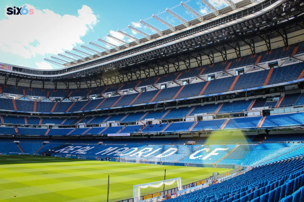 The image features a large, empty stadium with a blue-and-white color scheme. stadium shows ICC Cricket Ranking.